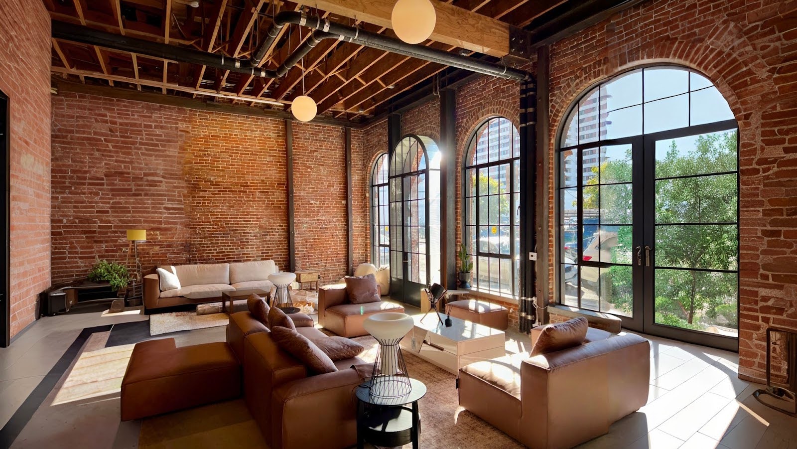 A spacious luxury living room furniture store in Los Angeles with exposed brick walls and large arched windows.