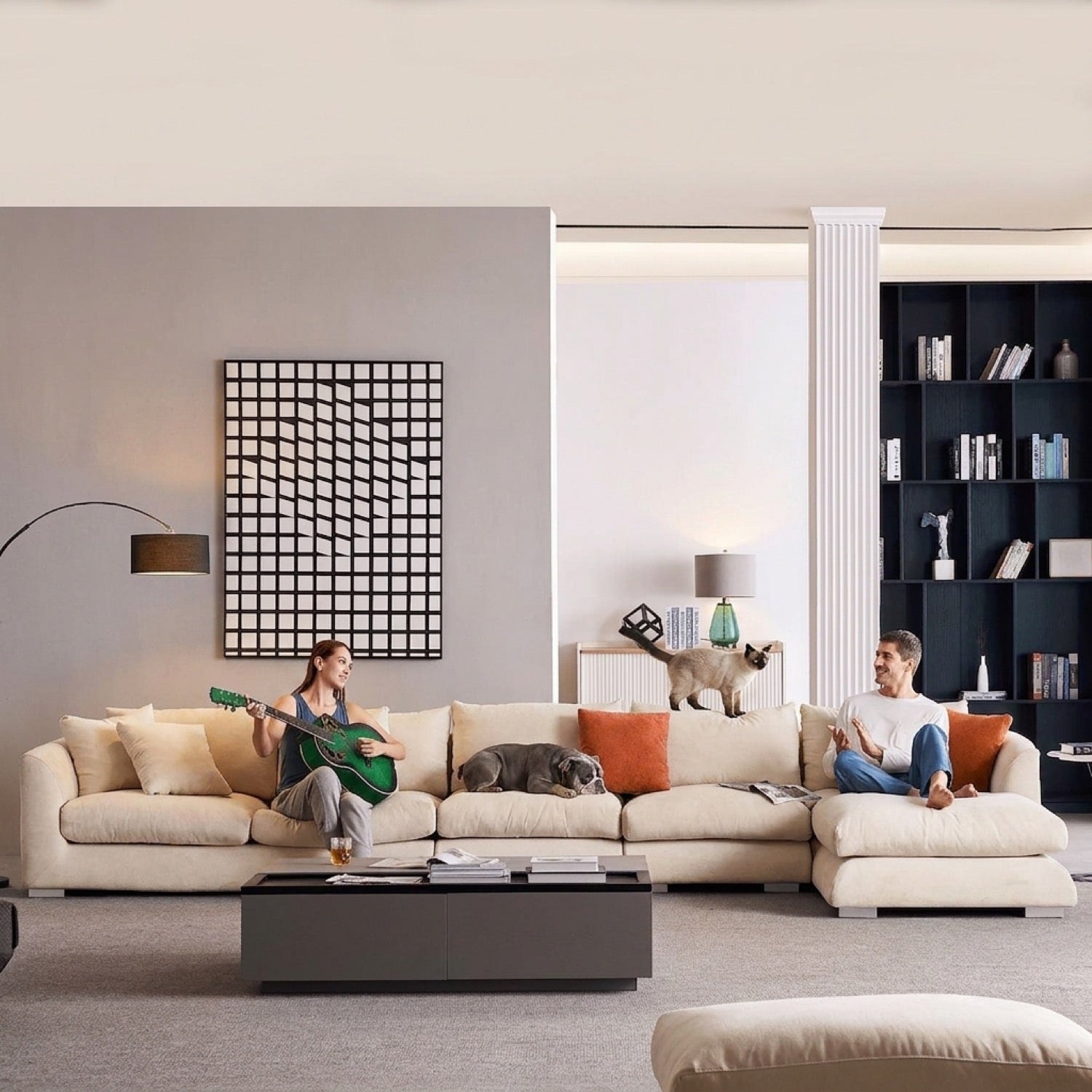 Beige sectional sofa in a modern living room with two people, a cat, and a dog